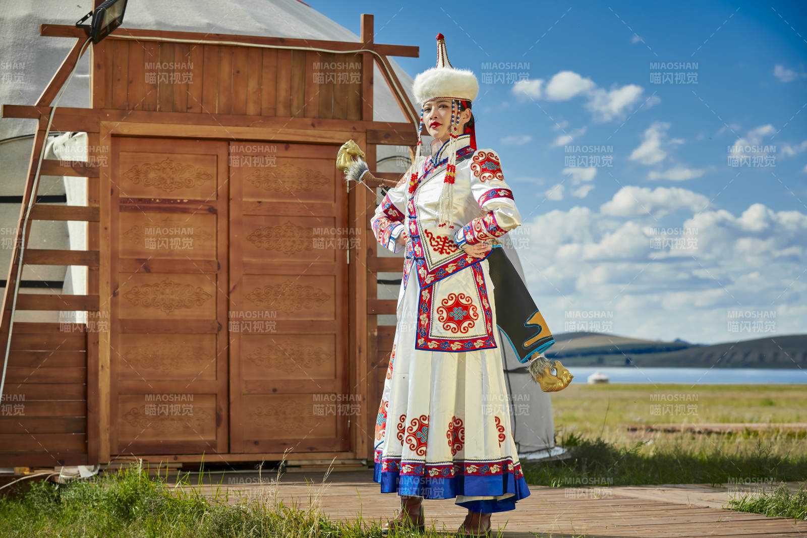 草原湖畔身穿蒙古族飾手持弓箭的蒙族少女