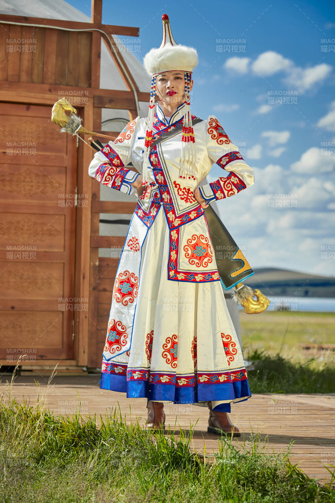 草原湖畔身穿蒙古族飾手持弓箭的蒙族少女