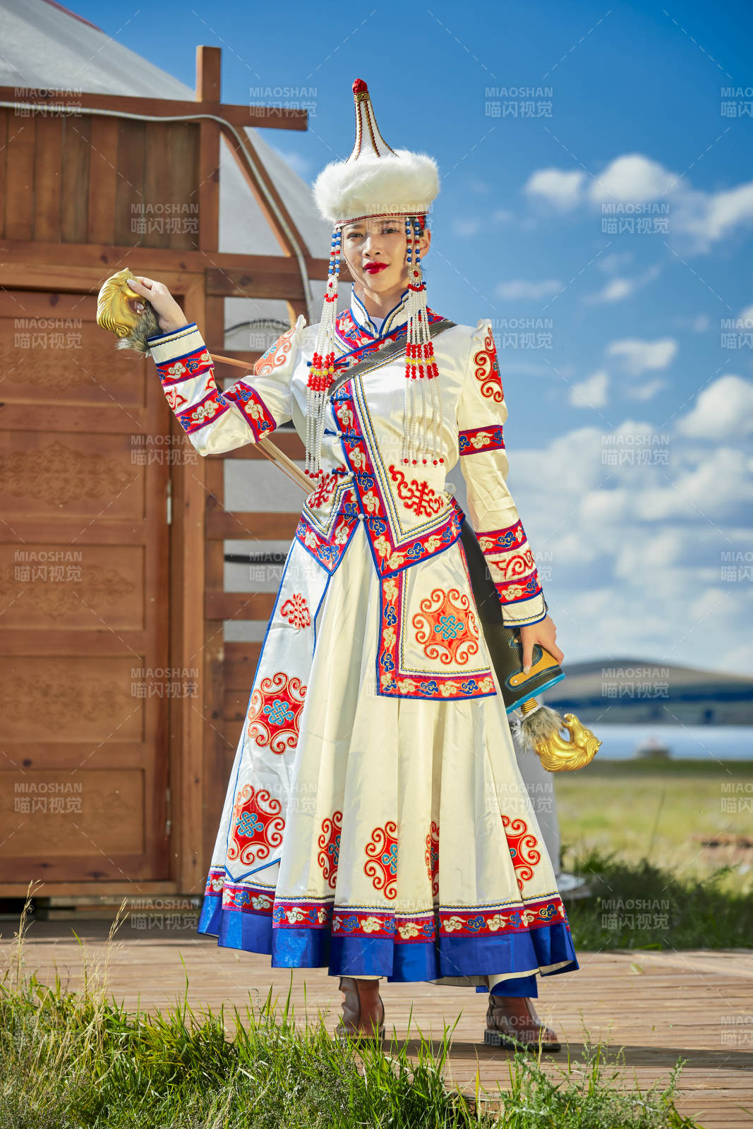 草原湖畔身穿蒙古族飾手持弓箭的蒙族少女