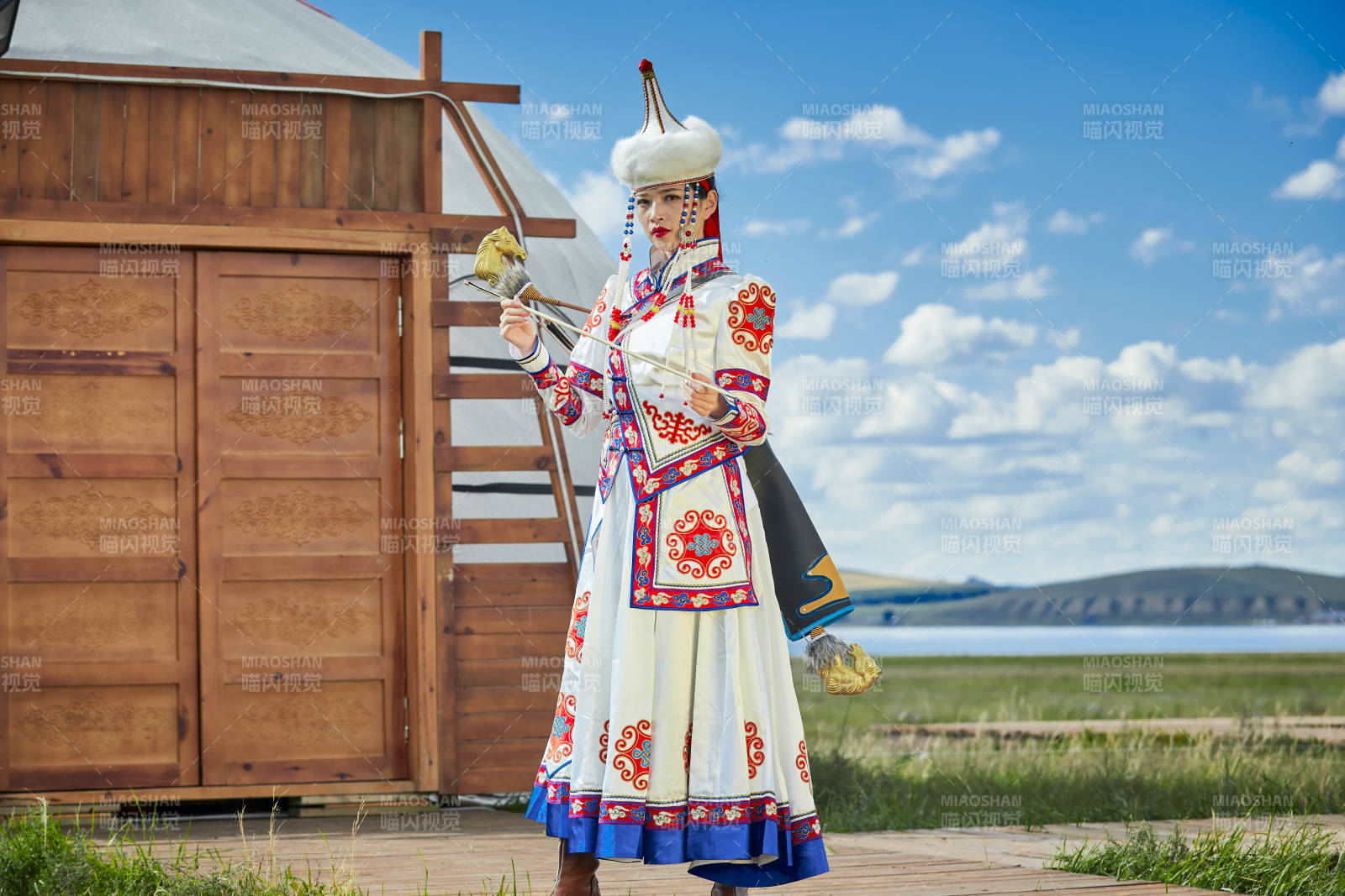 草原湖畔身穿蒙古族飾手持弓箭的蒙族少女