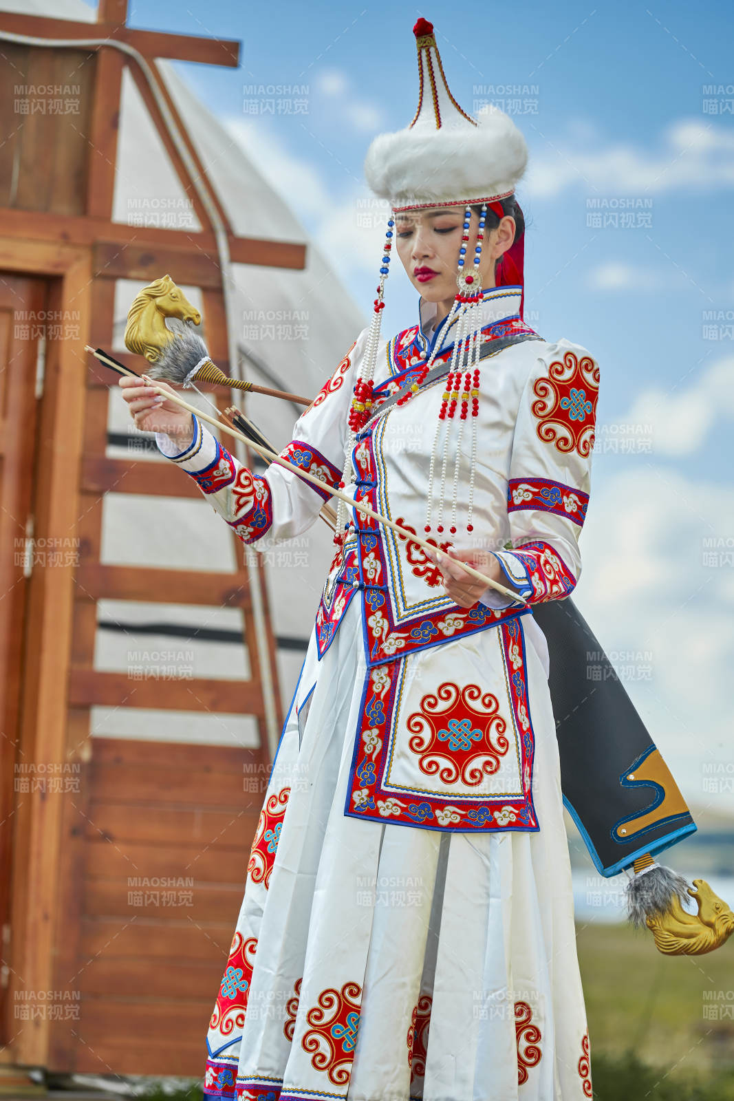 草原湖畔身穿蒙古族飾手持弓箭的蒙族少女