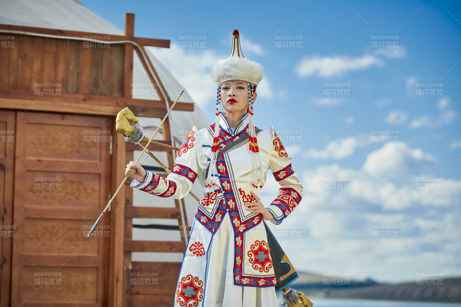 草原湖畔身穿蒙古族飾手持弓箭的蒙族少女