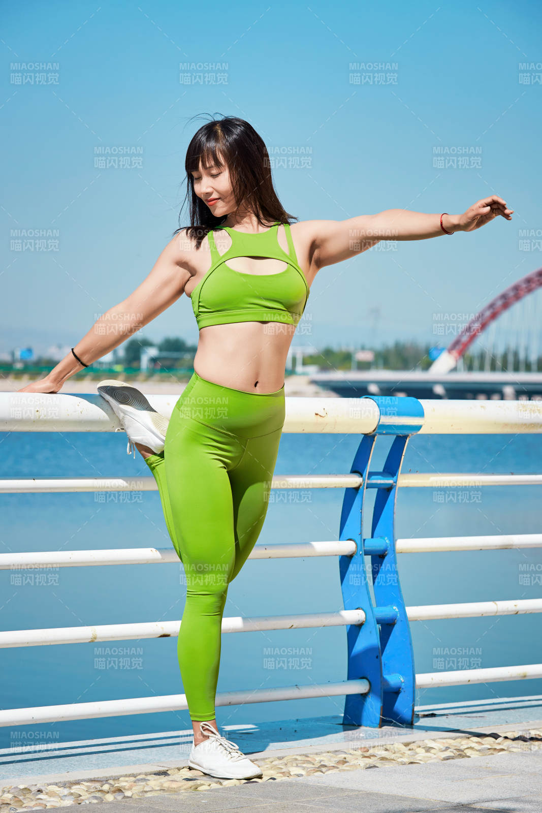 戶外河畔公園做拉伸有氧運(yùn)動(dòng)的亞洲女性