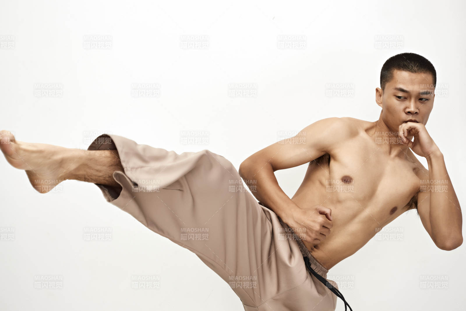 白色背景下演示自由搏擊動(dòng)作的亞洲功夫男性