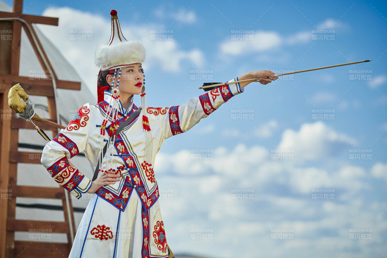 草原湖畔身穿蒙古族飾手持弓箭的蒙族少女