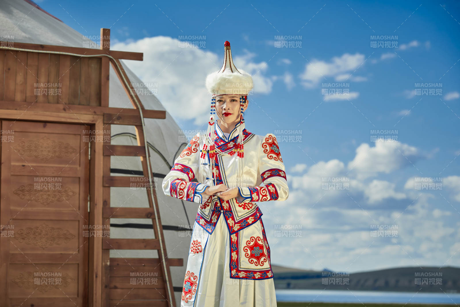 草原湖畔身穿蒙古族飾手持弓箭的蒙族少女