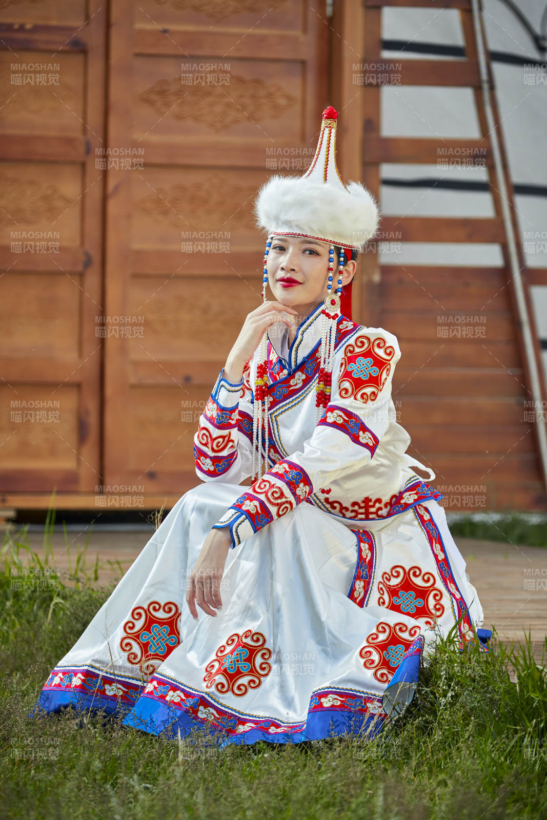 草原湖畔身穿蒙古族飾手持弓箭的蒙族少女