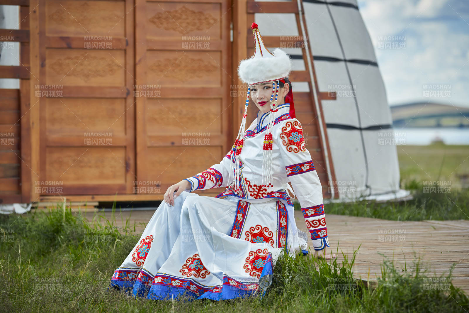 草原湖畔身穿蒙古族飾手持弓箭的蒙族少女