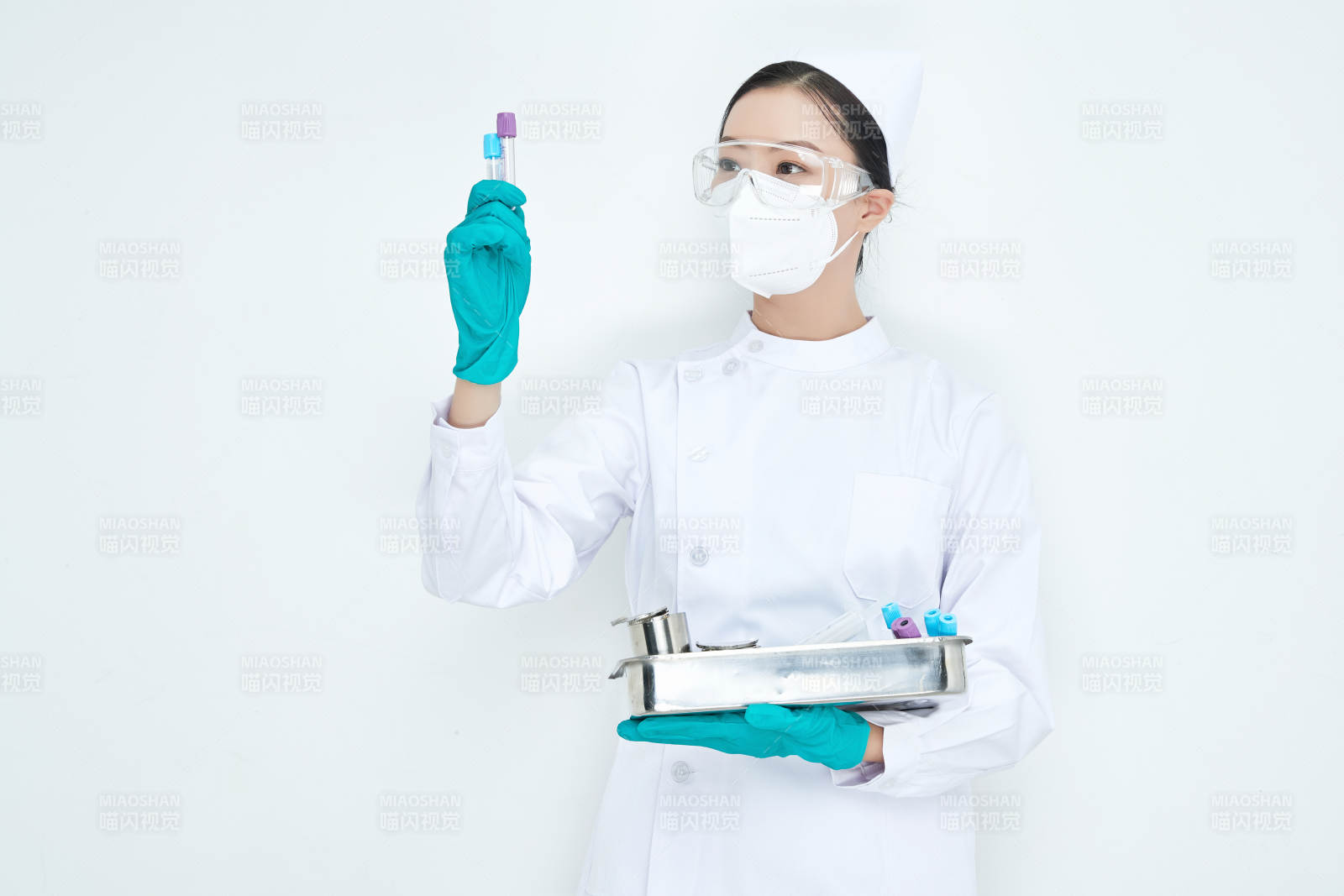 身穿護士服手抱化驗托盤的年輕女護士