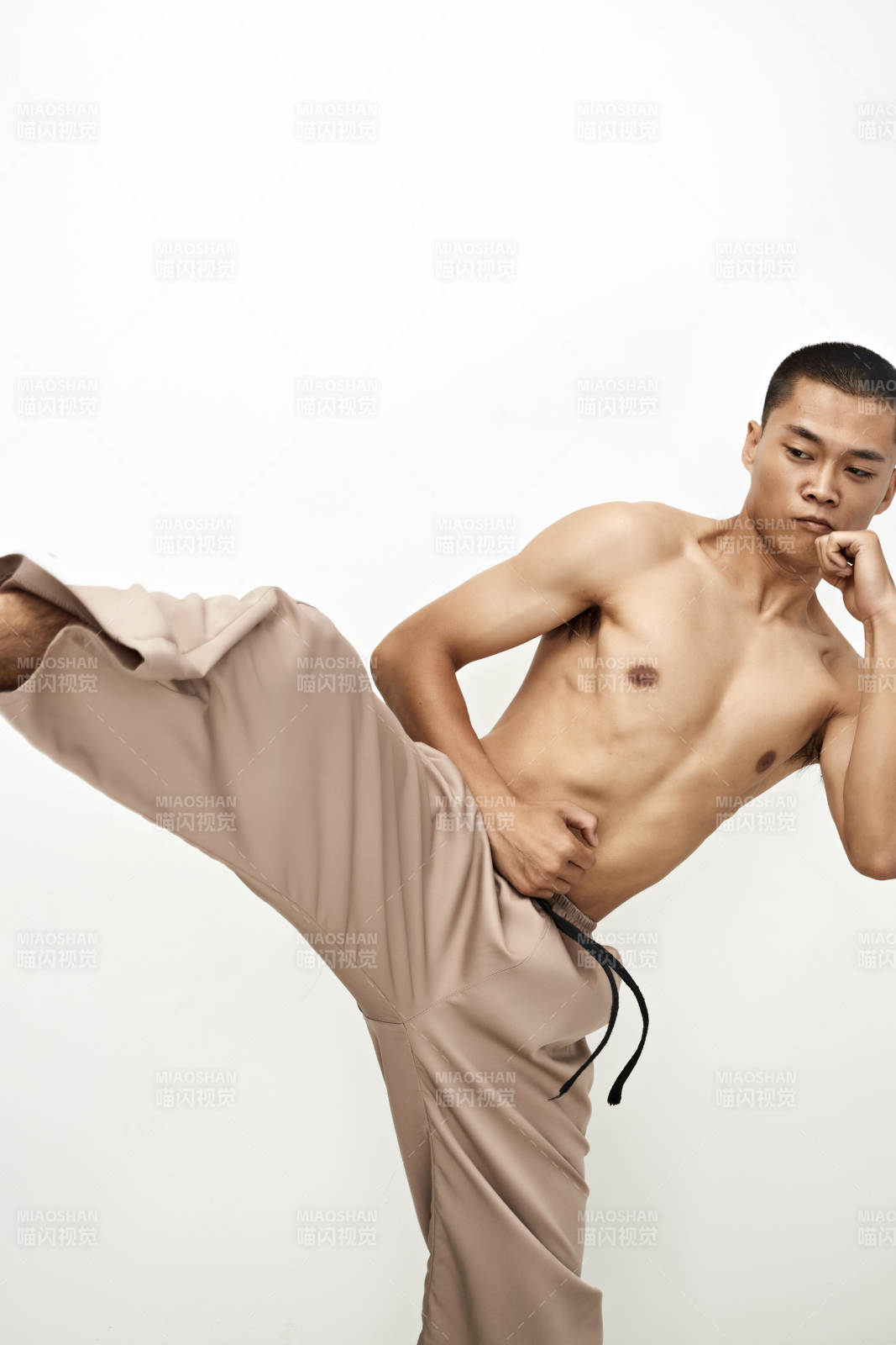 白色背景下演示自由搏擊動作的亞洲功夫男性