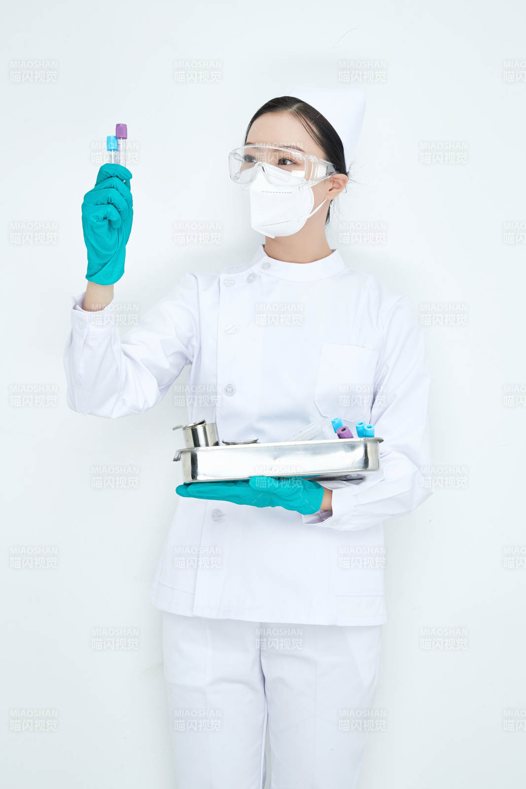 身穿護士服手抱化驗托盤的年輕女護士