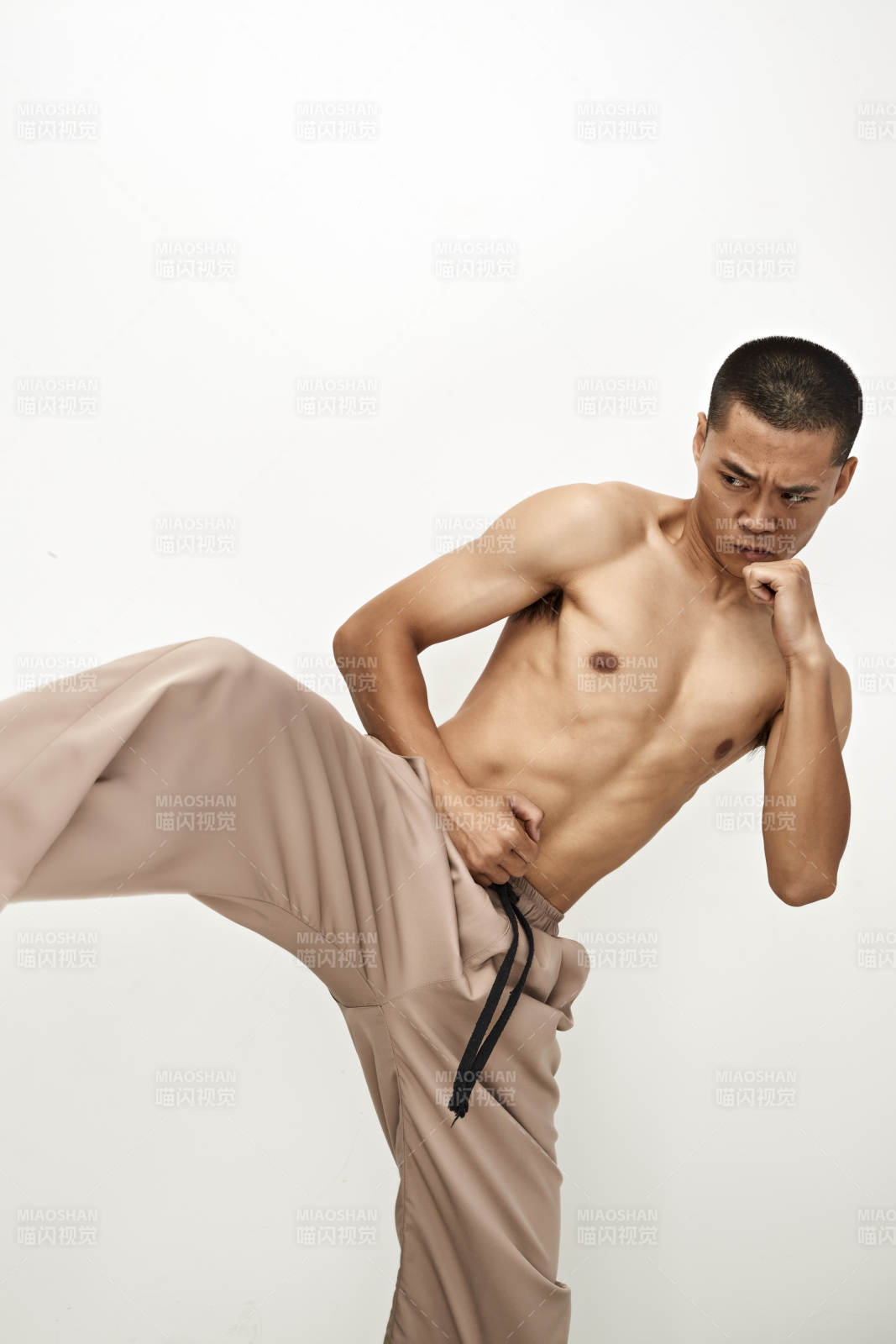 白色背景下演示自由搏擊動(dòng)作的亞洲功夫男性