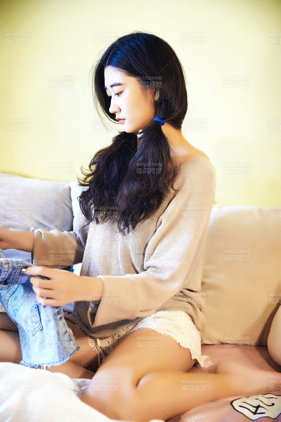 在沙發床上整理行裝的年輕亞洲女性