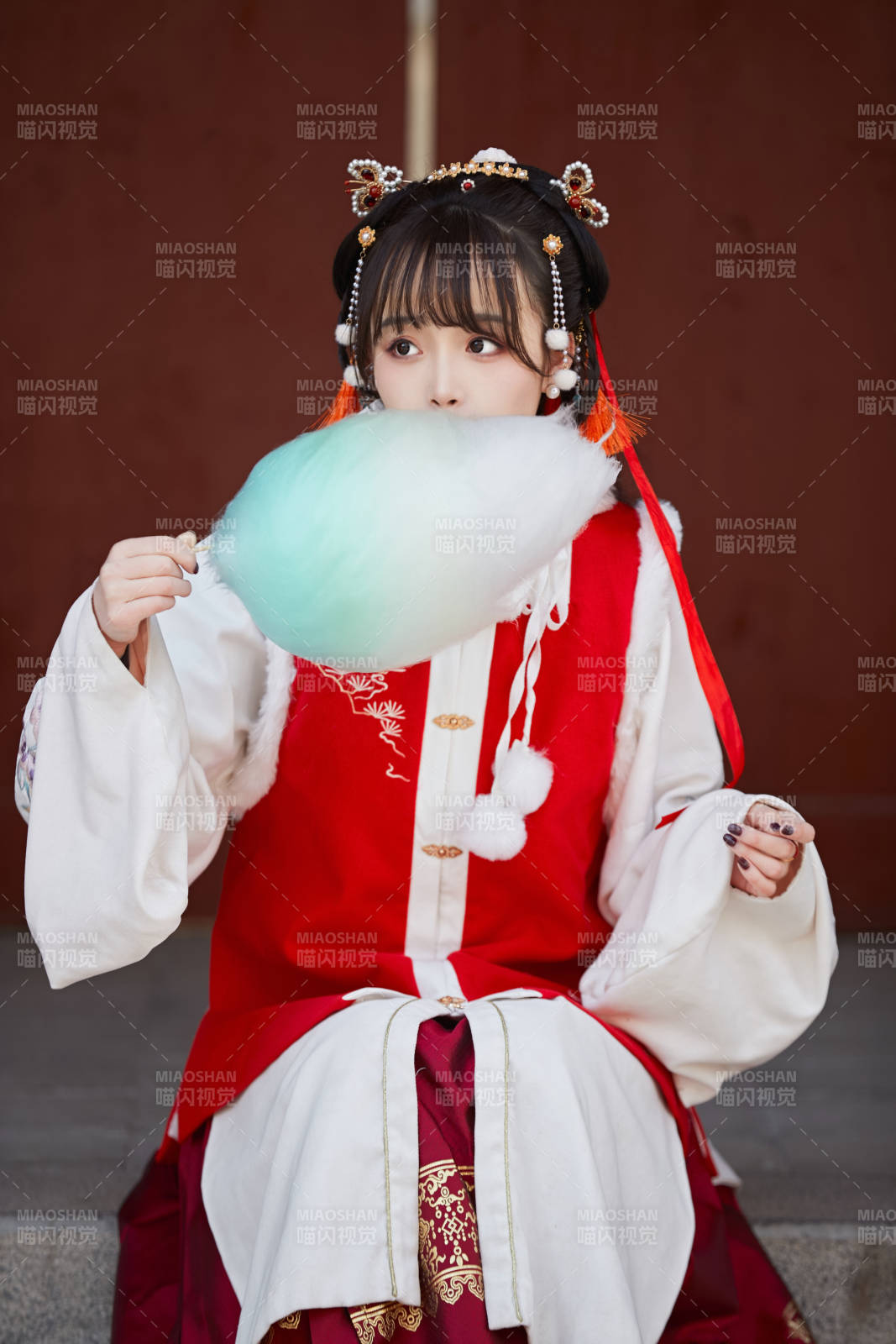 身穿喜慶漢服吃棉花糖的少女