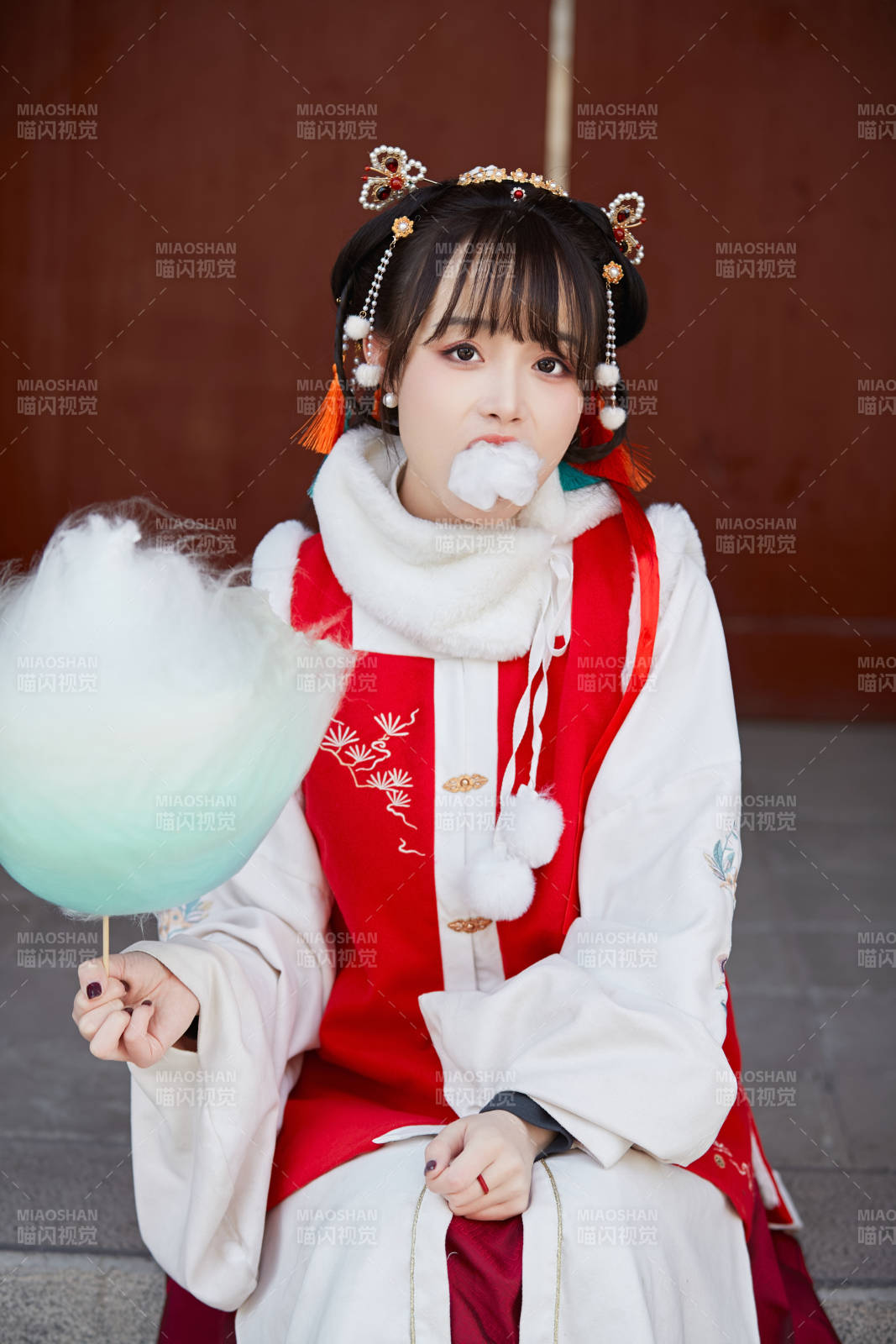 身穿喜慶漢服吃棉花糖的少女