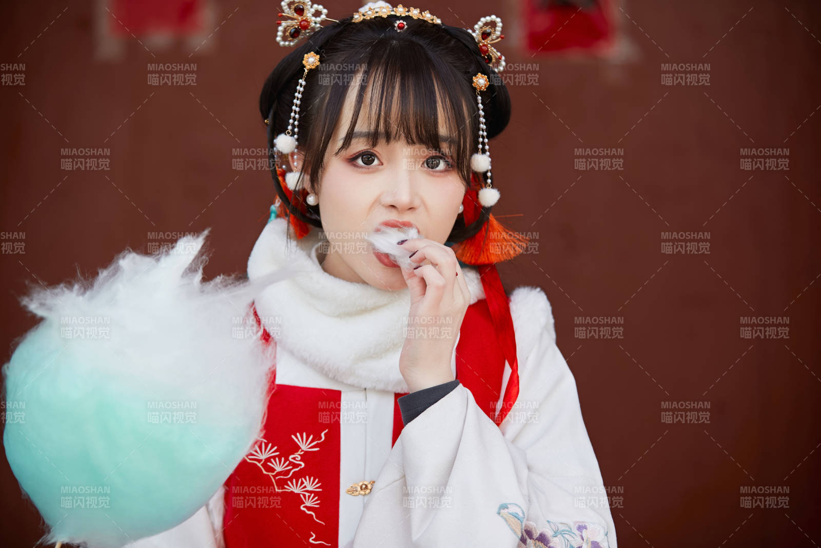 身穿喜慶漢服吃棉花糖的少女