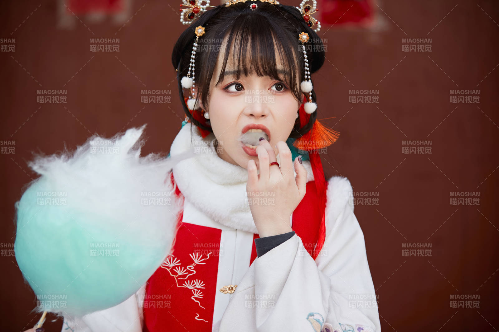 身穿喜慶漢服吃棉花糖的少女