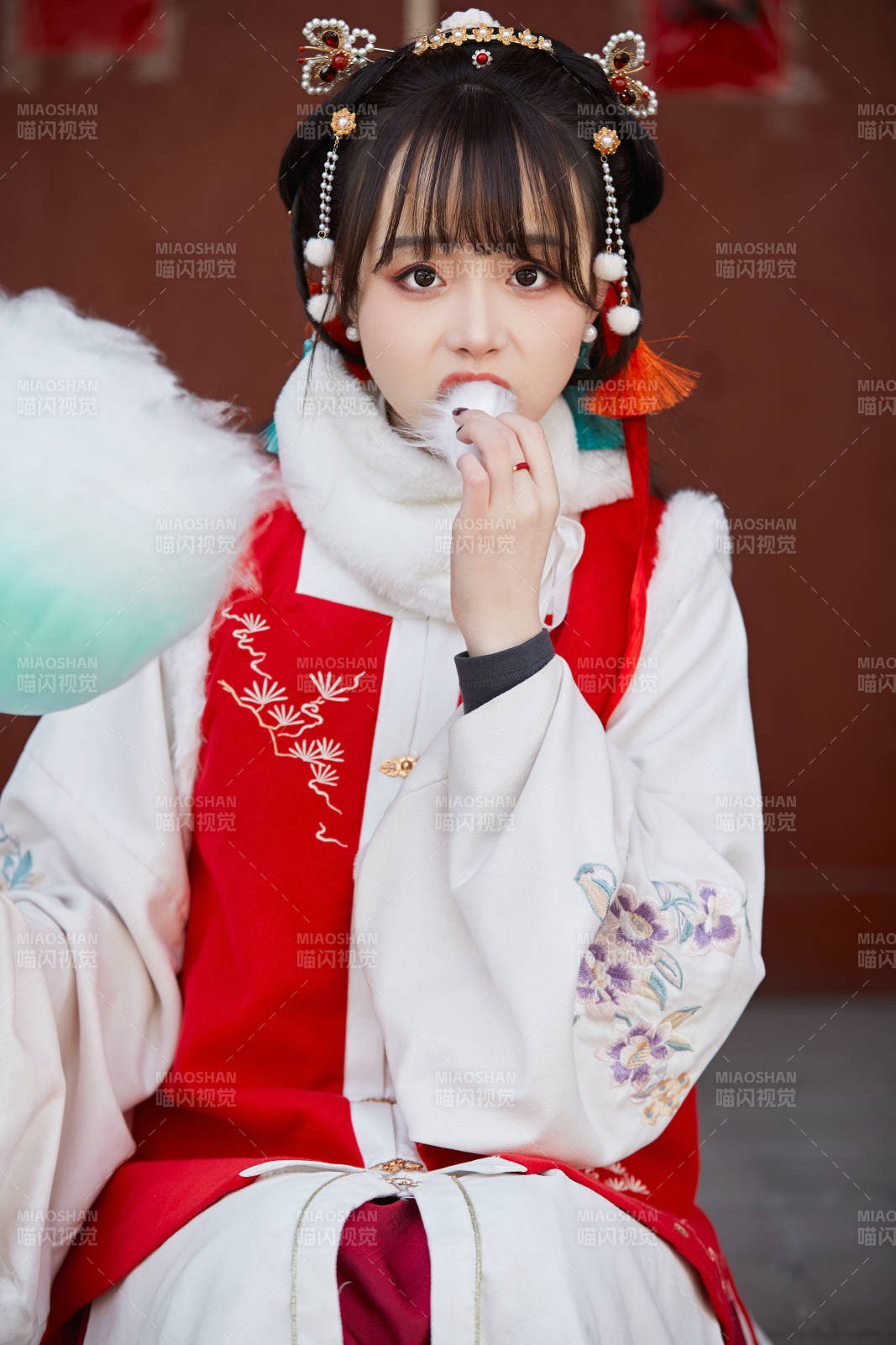 身穿喜慶漢服吃棉花糖的少女