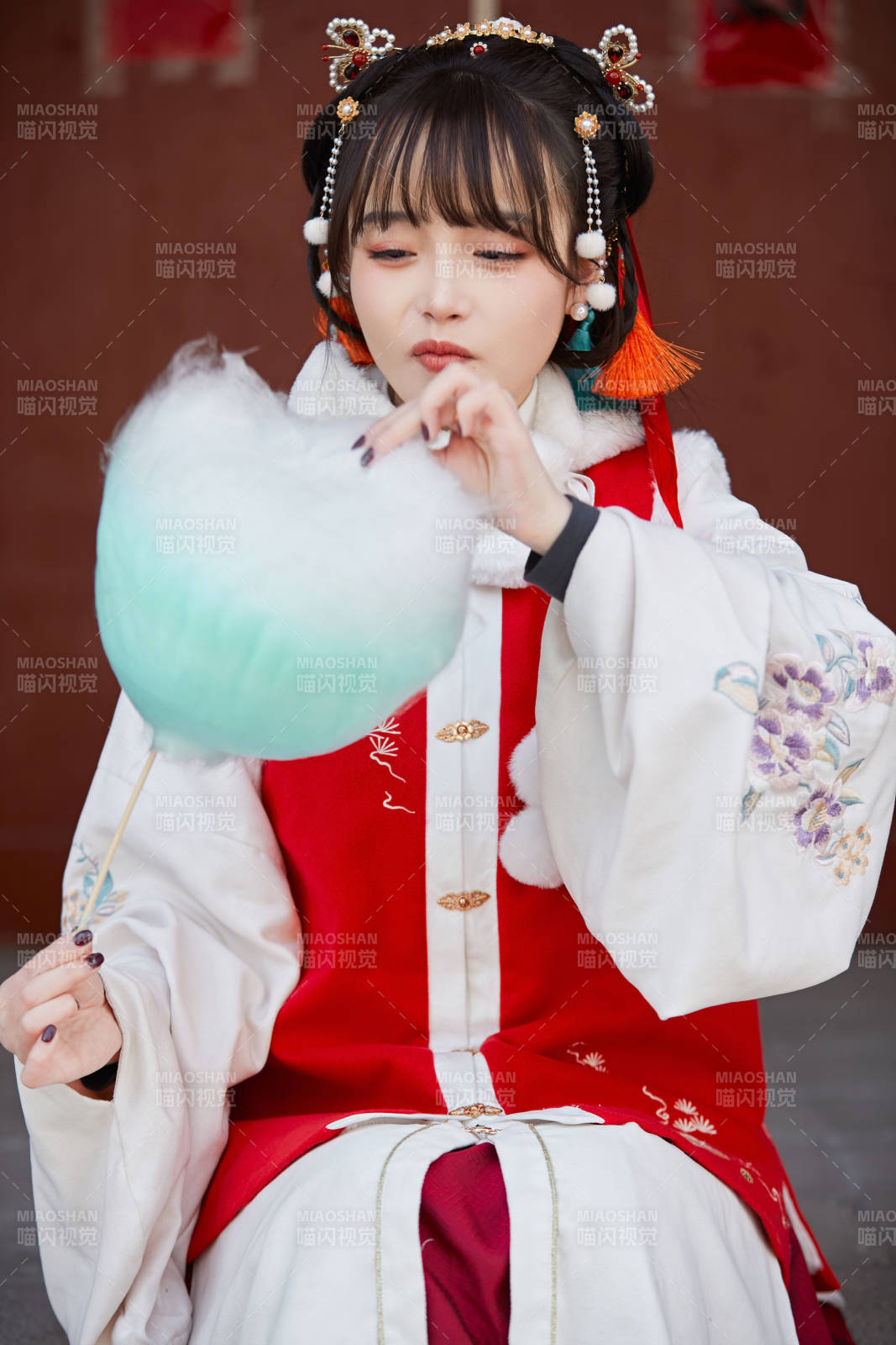 身穿喜慶漢服吃棉花糖的少女