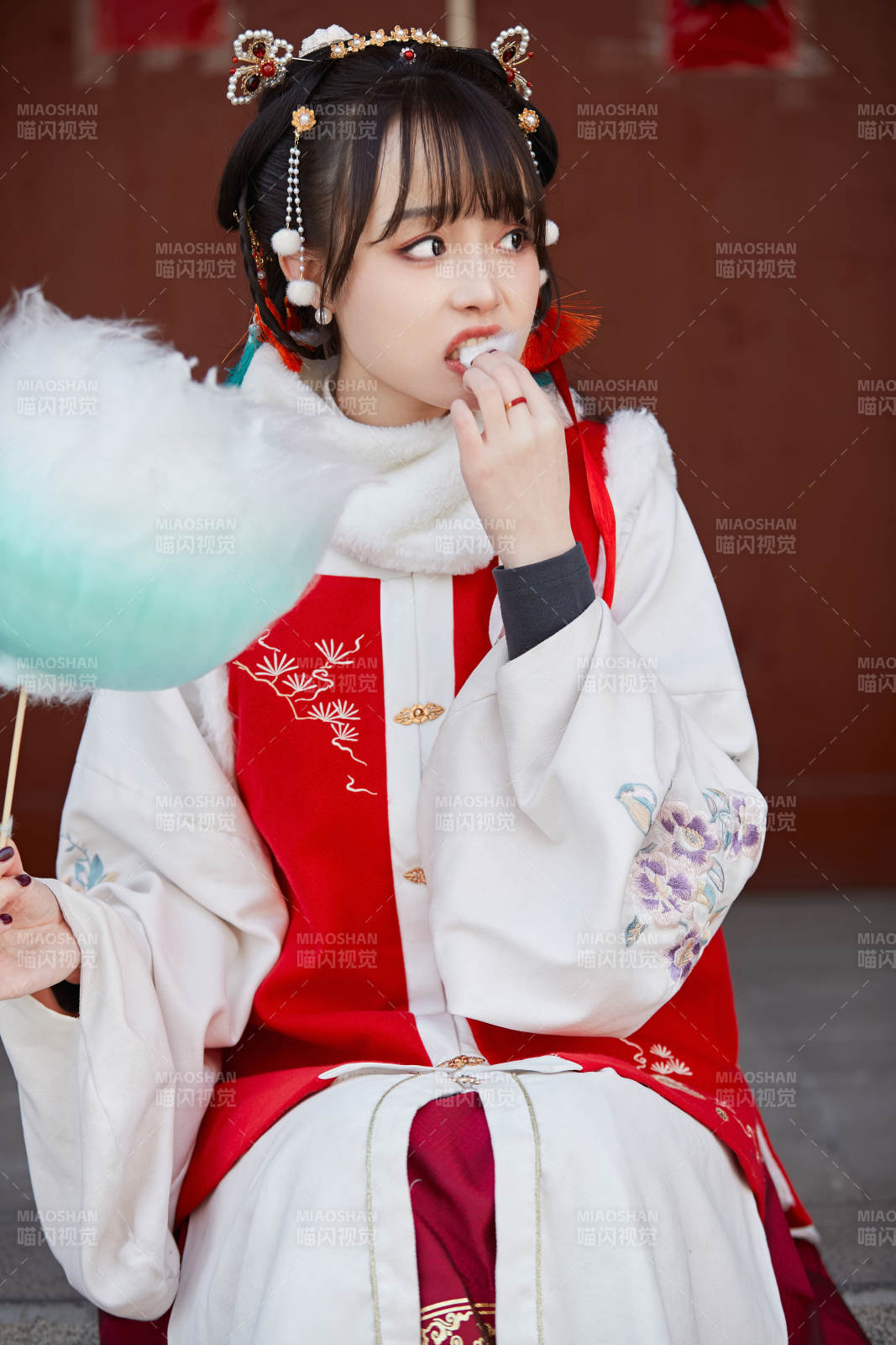 身穿喜慶漢服吃棉花糖的少女