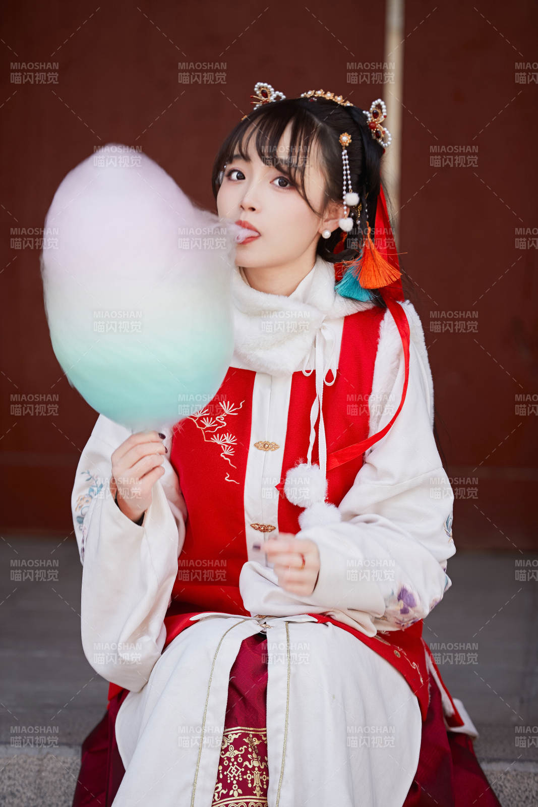 身穿喜慶漢服吃棉花糖的少女