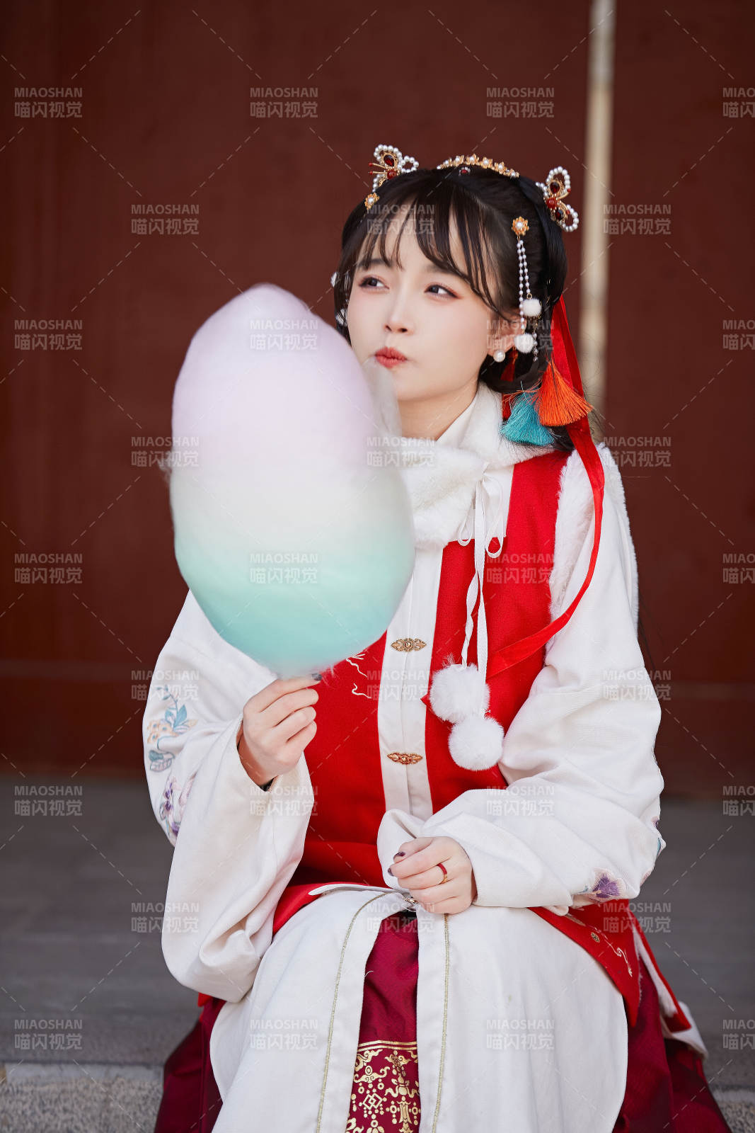 身穿喜慶漢服吃棉花糖的少女