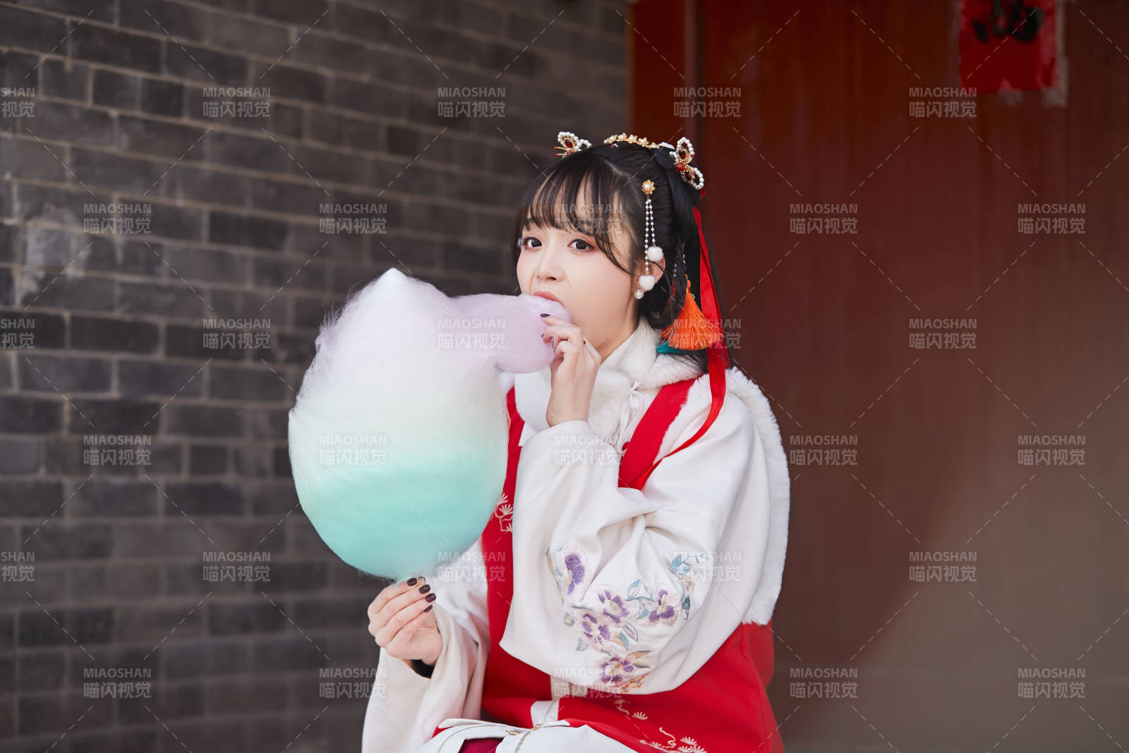 身穿喜慶漢服吃棉花糖的少女