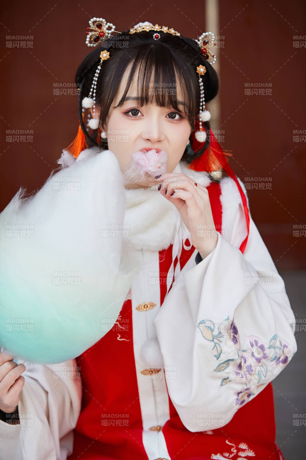 身穿喜慶漢服吃棉花糖的少女