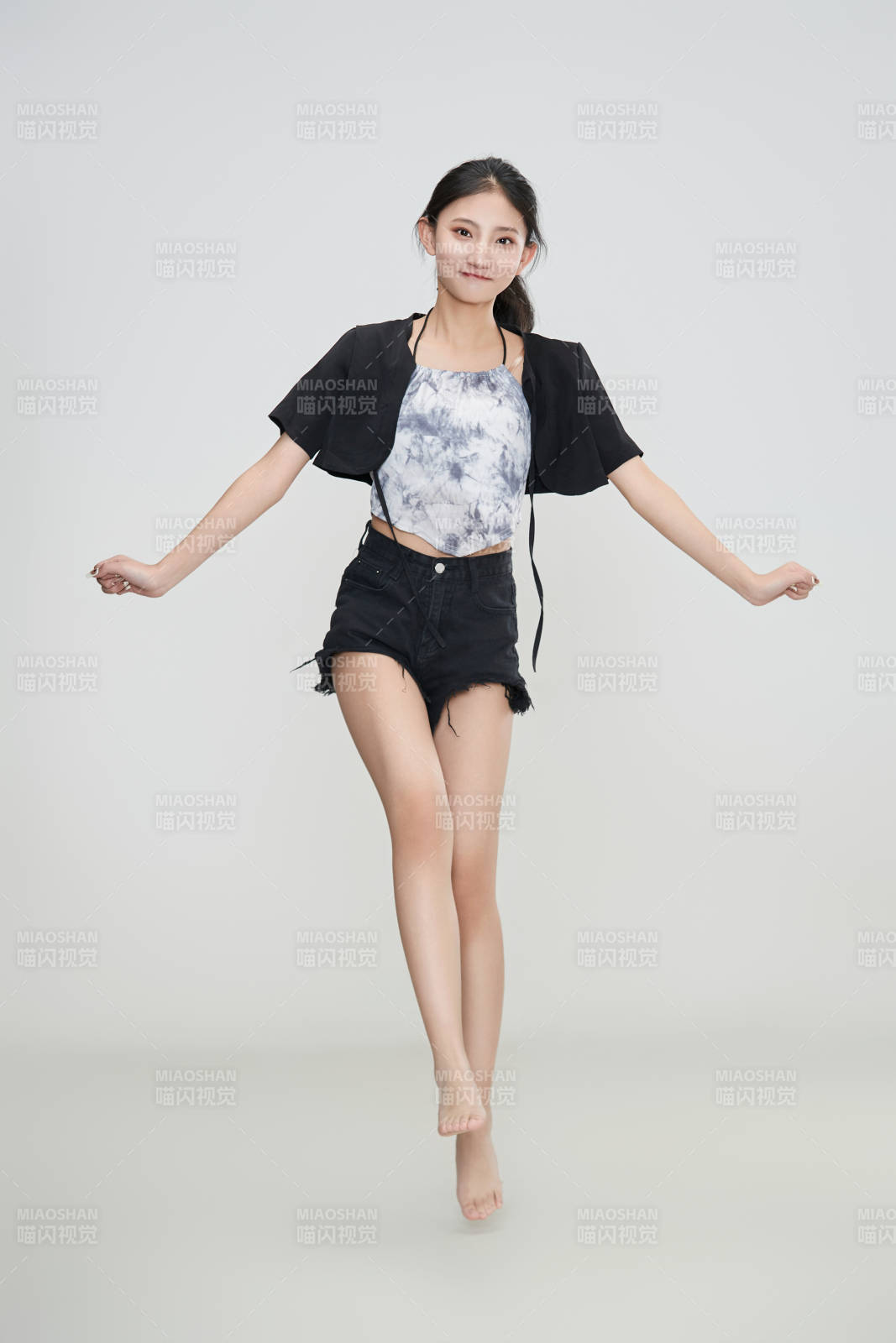 白色背景下騰空跳躍的可愛亞洲少女