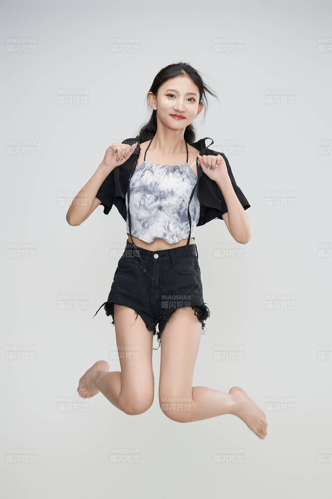 白色背景下騰空跳躍的可愛亞洲少女