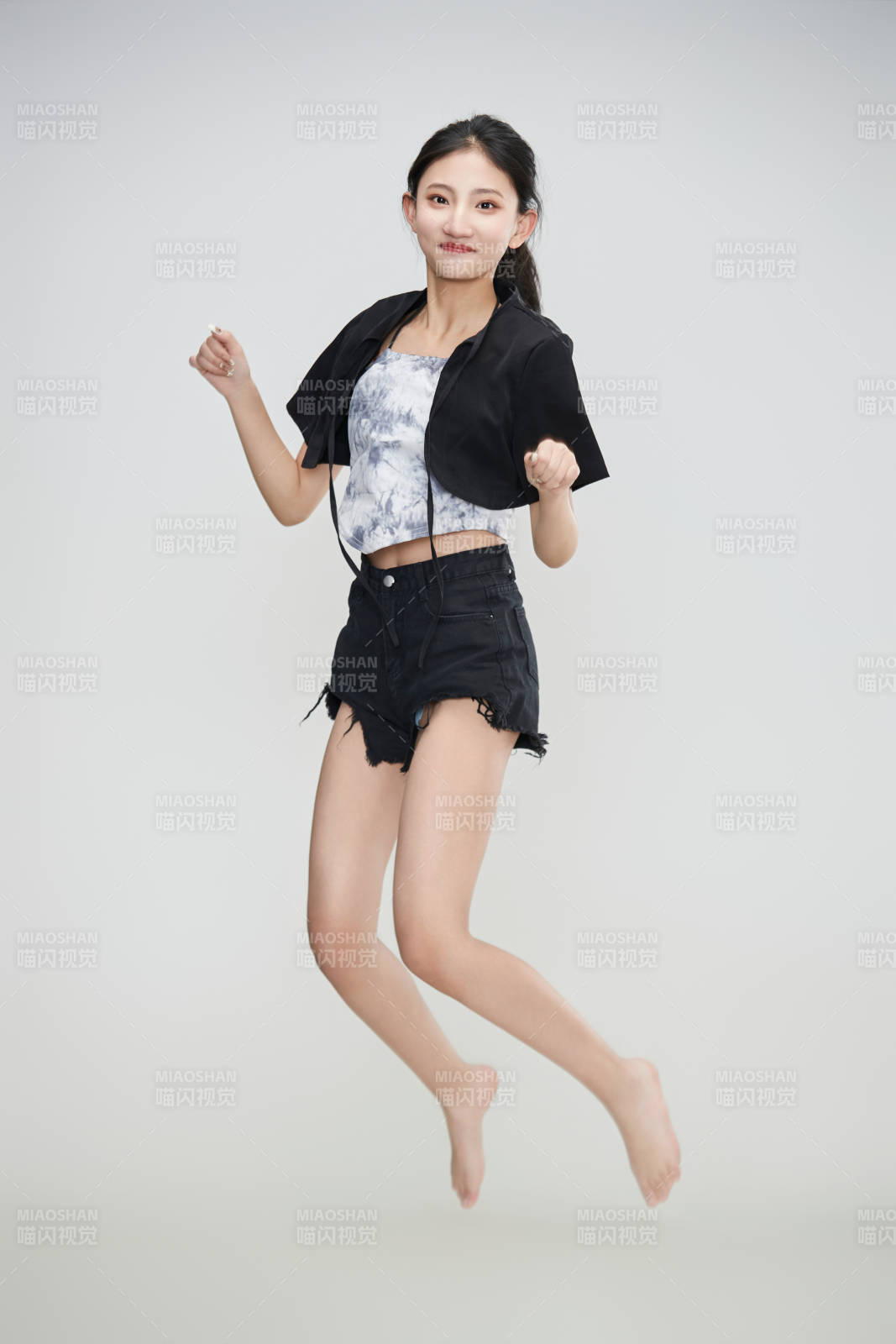 白色背景下騰空跳躍的可愛亞洲少女