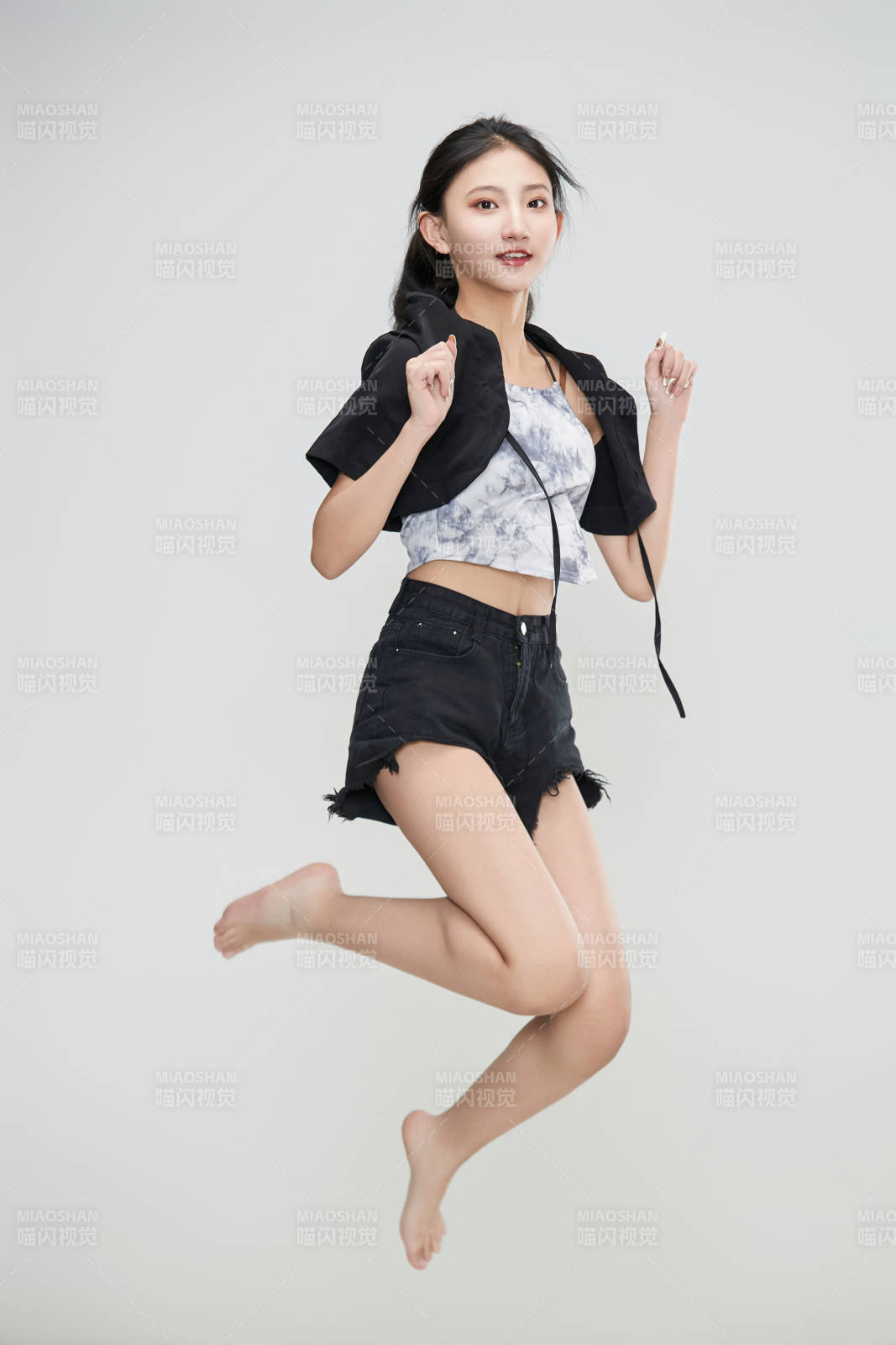 白色背景下騰空跳躍的可愛亞洲少女