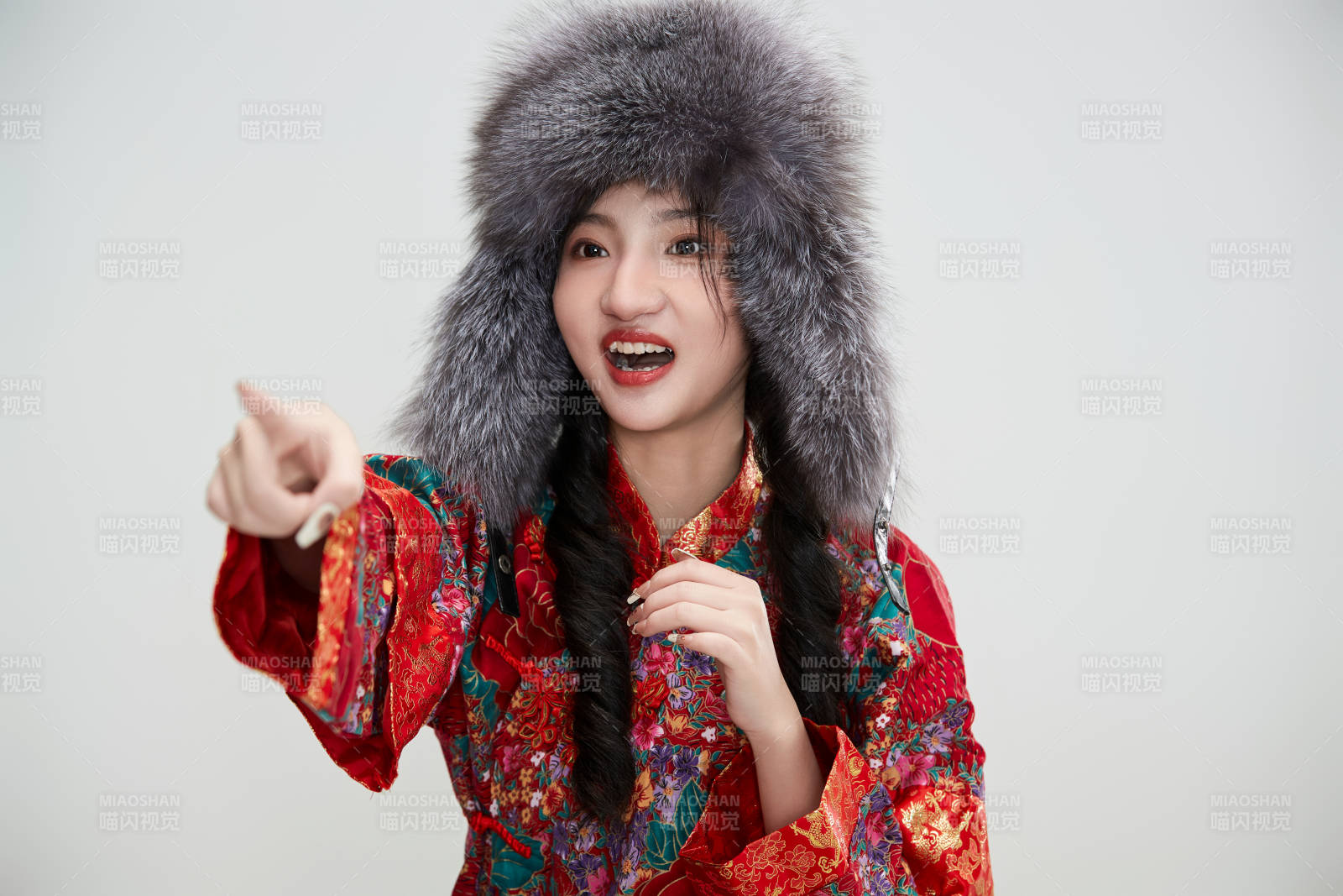 白色背景下穿中國傳統服飾頭戴絨帽的少女