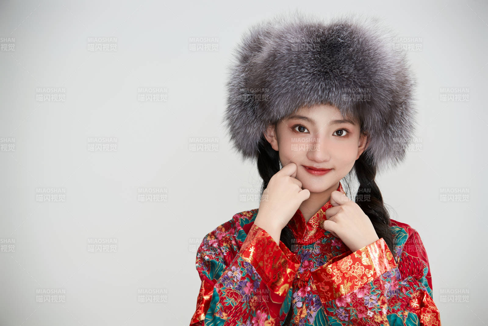 白色背景下穿中國傳統(tǒng)服飾頭戴絨帽的少女