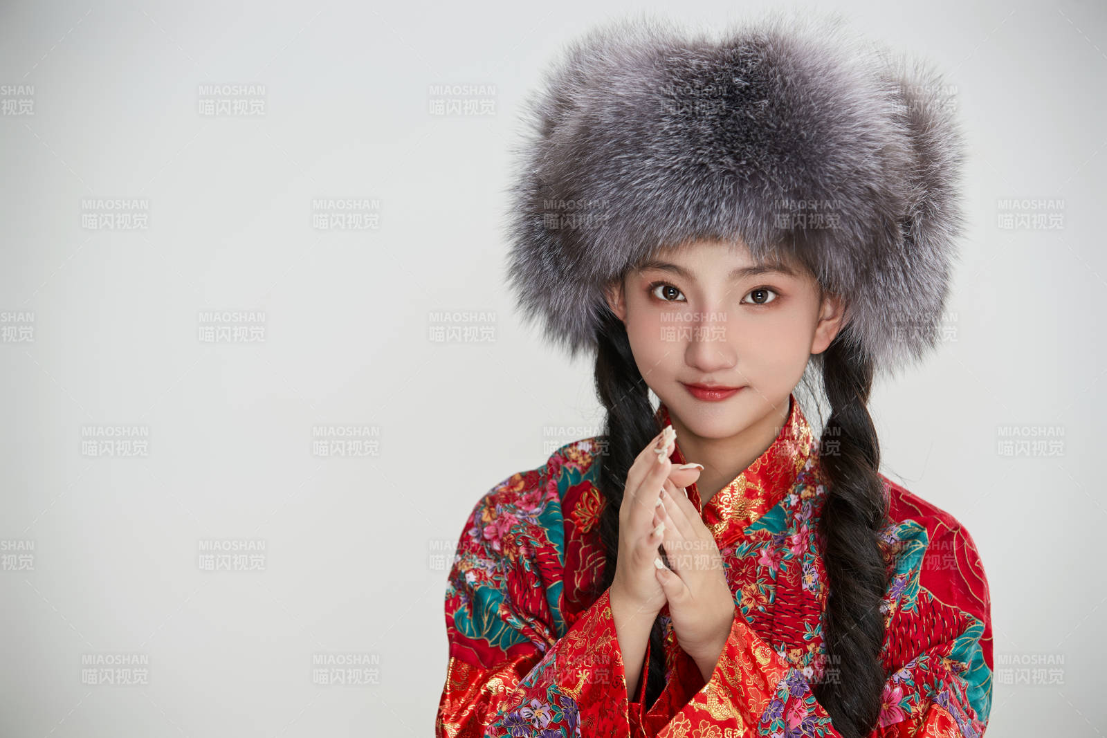 白色背景下穿中國(guó)傳統(tǒng)服飾頭戴絨帽的少女