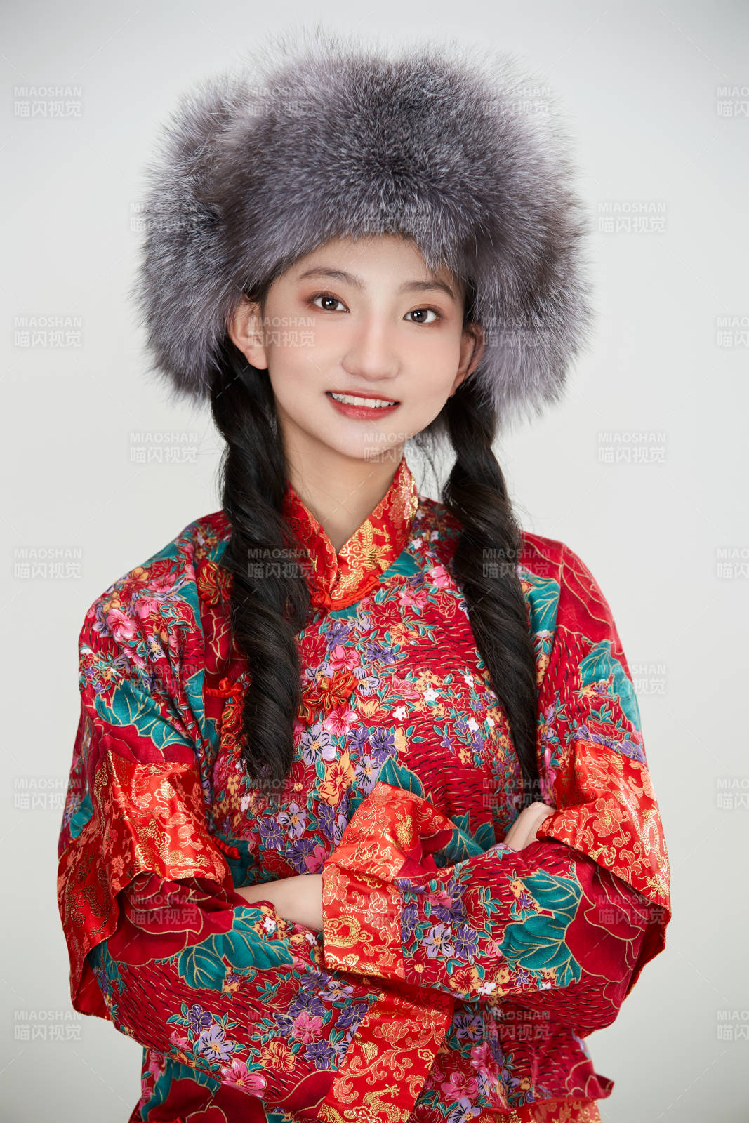 白色背景下穿中國傳統(tǒng)服飾頭戴絨帽的少女