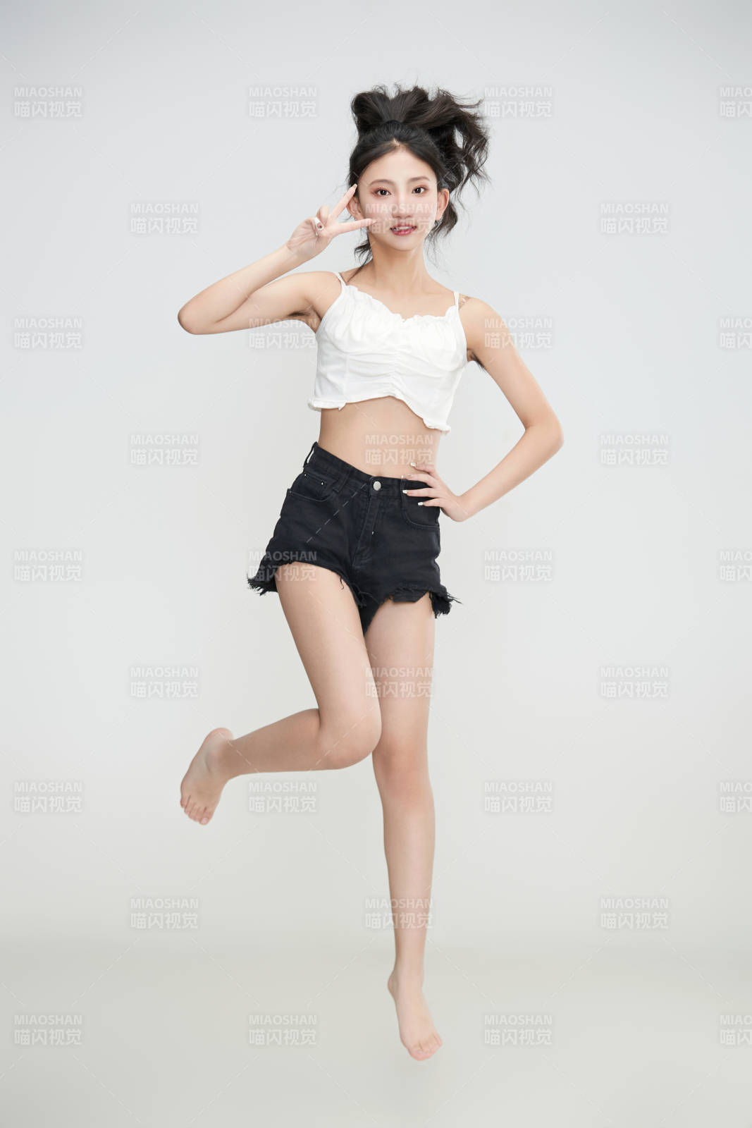 白色背景下騰空跳躍的可愛(ài)亞洲少女