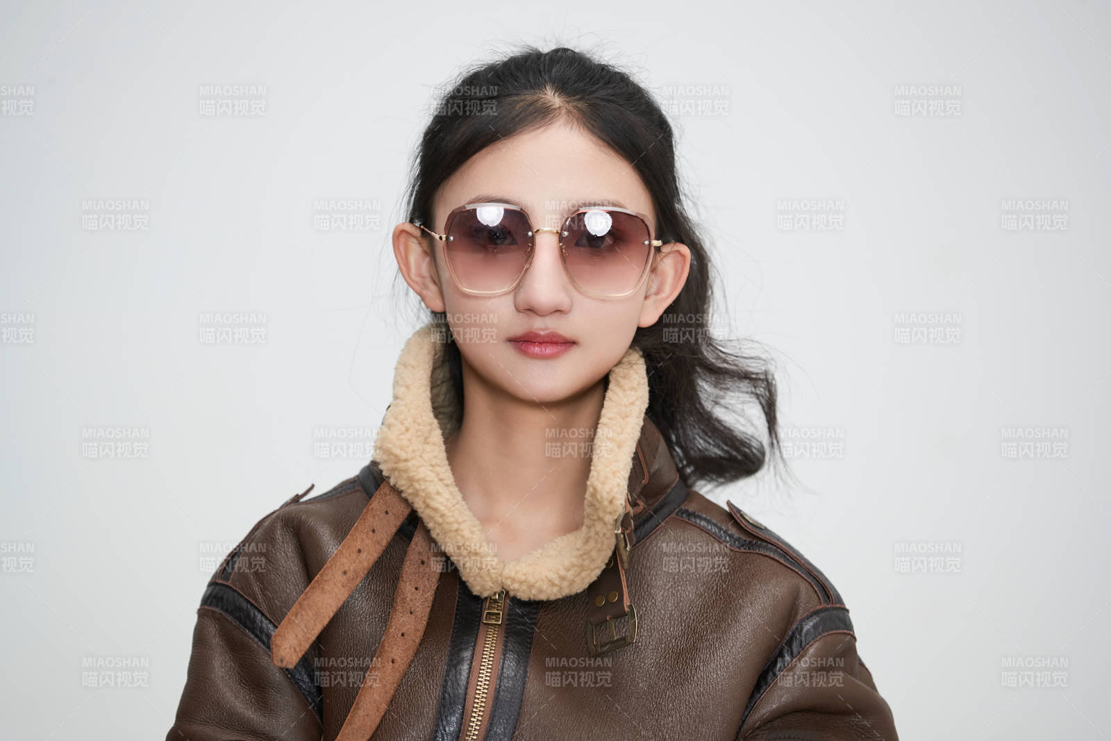 愛色背景下身穿飛行員皮夾克戴墨鏡的可愛少女