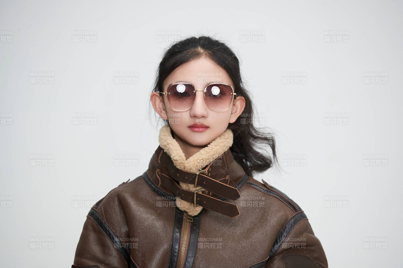 愛色背景下身穿飛行員皮夾克戴墨鏡的可愛少女