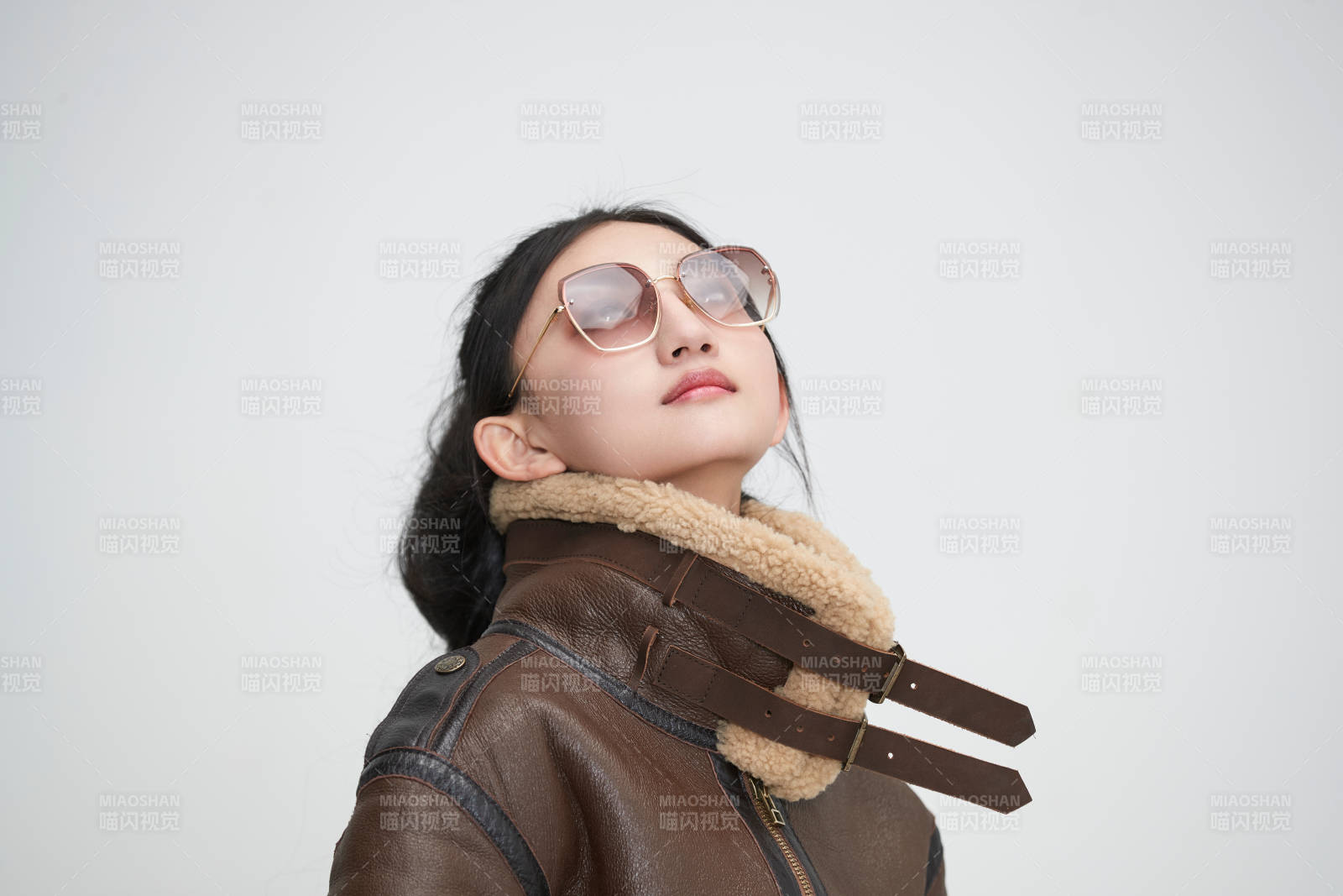 愛色背景下身穿飛行員皮夾克戴墨鏡的可愛少女