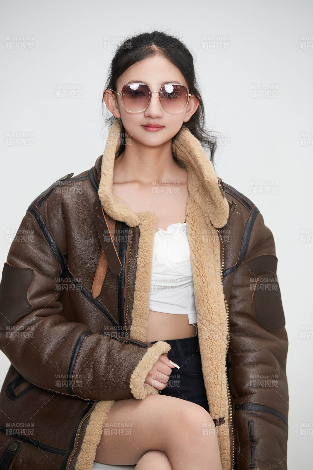 愛色背景下身穿飛行員皮夾克戴墨鏡的可愛少女