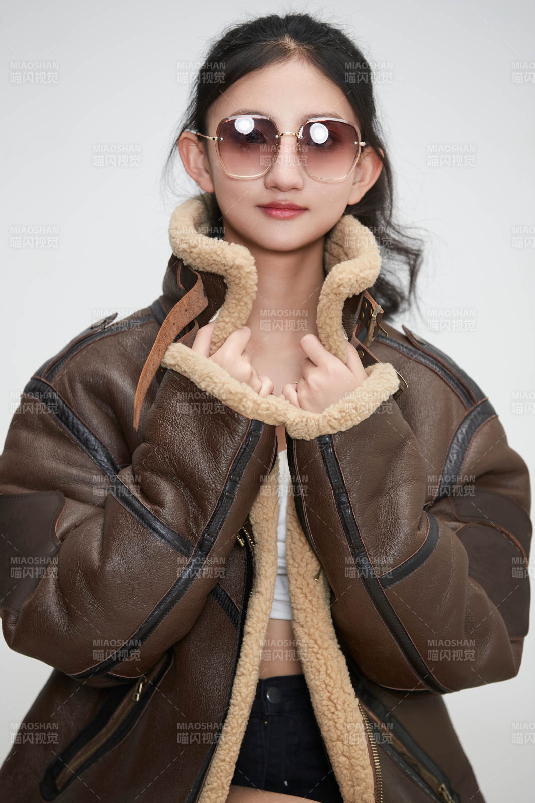 愛色背景下身穿飛行員皮夾克戴墨鏡的可愛少女