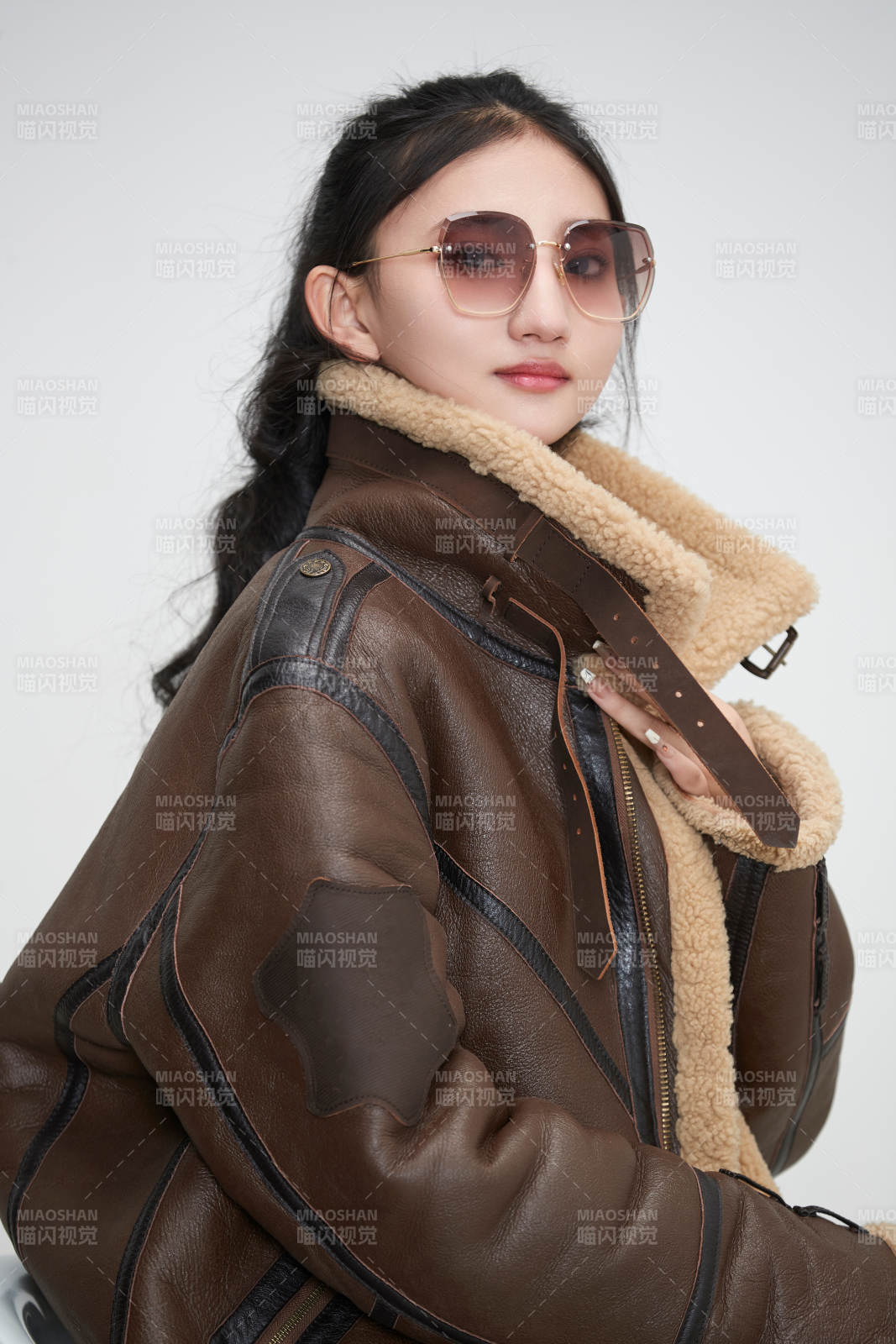 愛色背景下身穿飛行員皮夾克戴墨鏡的可愛少女