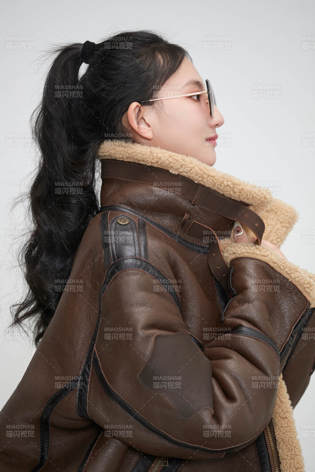 愛色背景下身穿飛行員皮夾克戴墨鏡的可愛少女