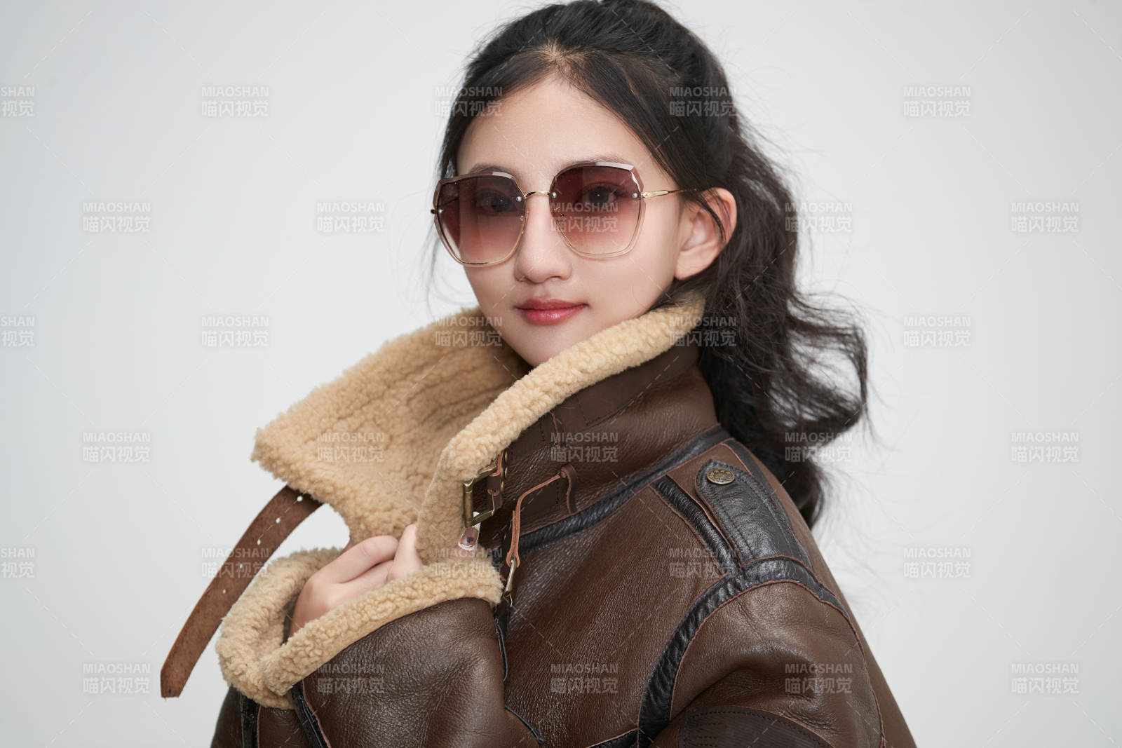 愛(ài)色背景下身穿飛行員皮夾克戴墨鏡的可愛(ài)少女
