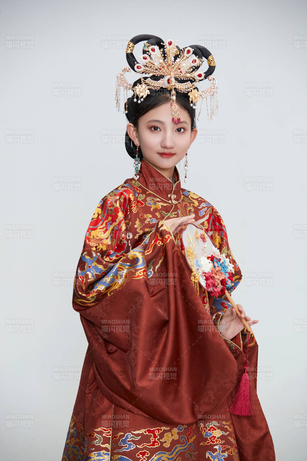 白色背景下穿著明代鳳冠霞帔漢服的可愛少女