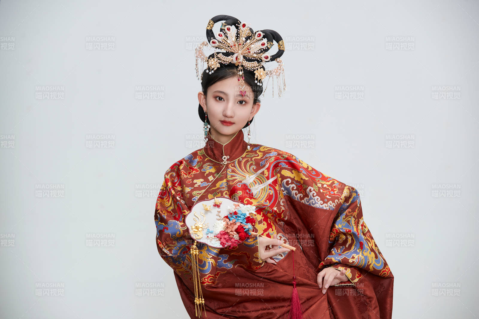白色背景下穿著明代鳳冠霞帔漢服的可愛少女