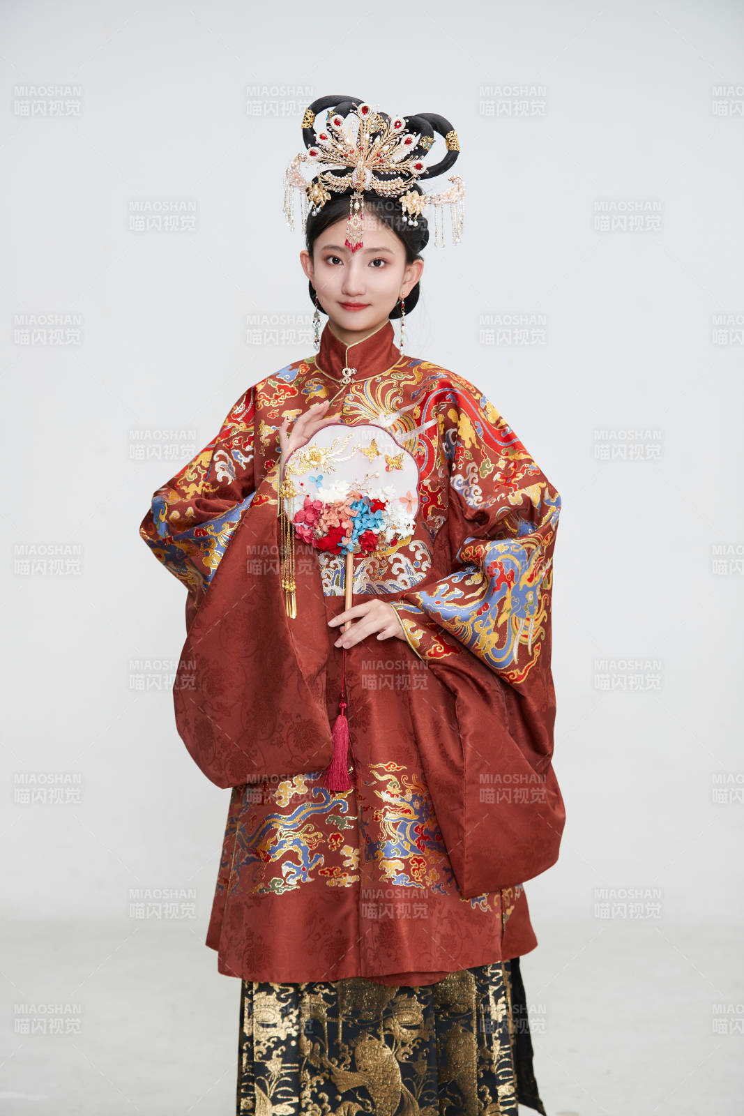 白色背景下穿著明代鳳冠霞帔漢服的可愛少女