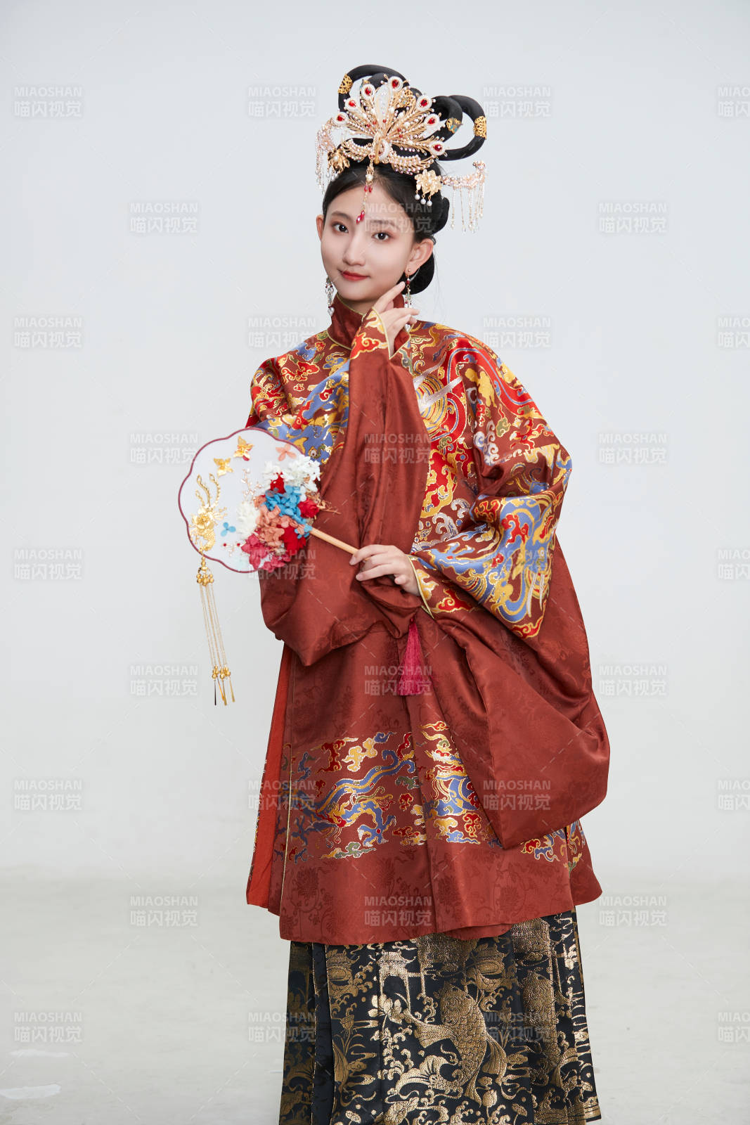 白色背景下穿著明代鳳冠霞帔漢服的可愛(ài)少女