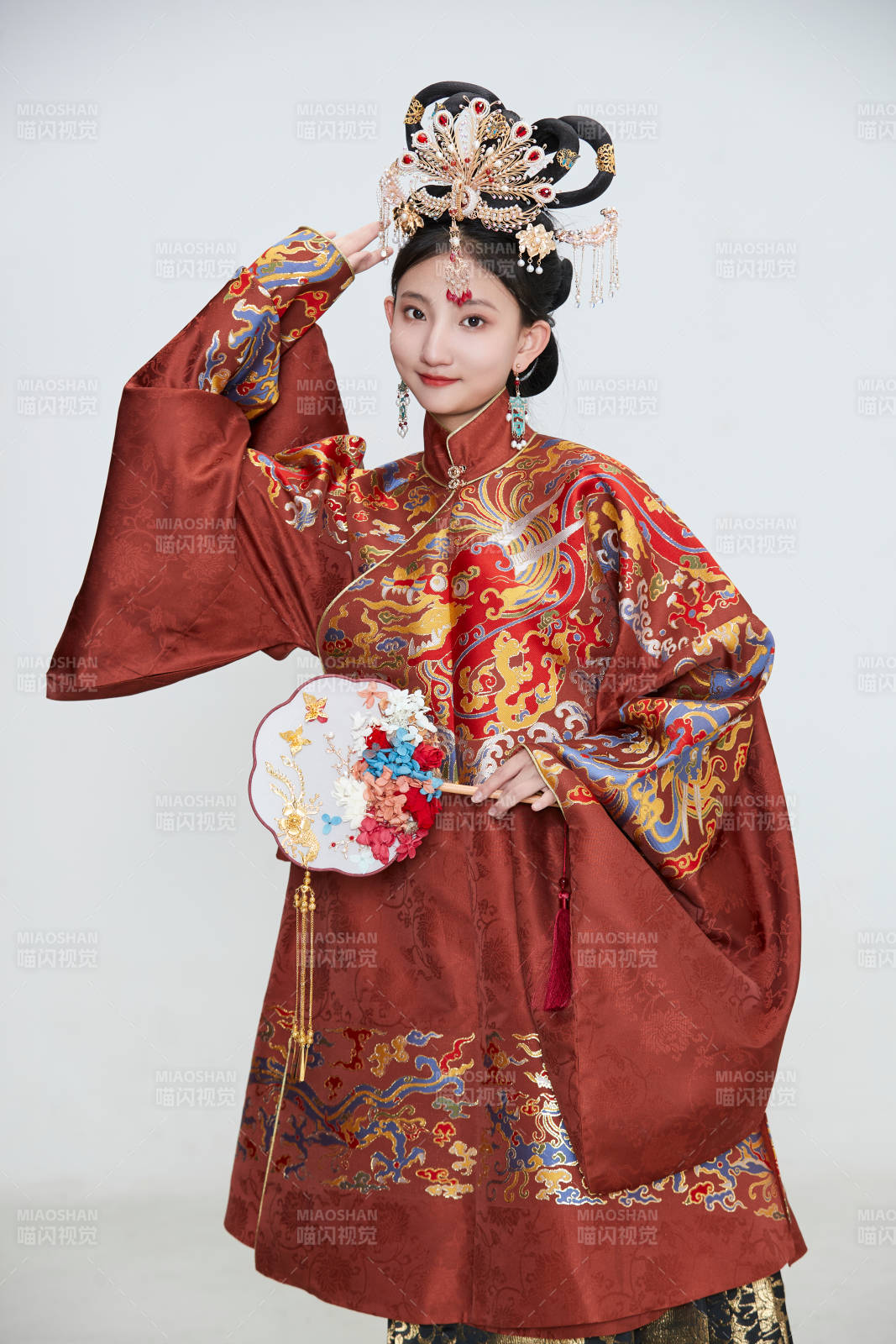 白色背景下穿著明代鳳冠霞帔漢服的可愛(ài)少女